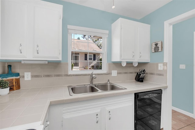 kitchen featuring dishwasher, white cabinetry, sink, and tile countertops