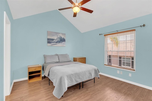 bedroom with ceiling fan, lofted ceiling, and light hardwood / wood-style flooring