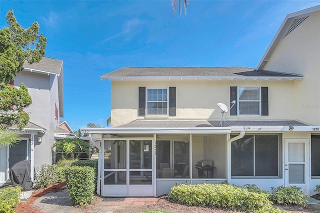 rear view of property featuring a sunroom