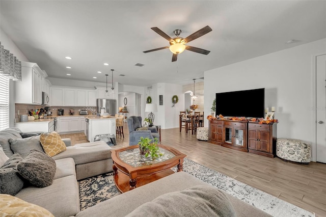 living room with ceiling fan and light hardwood / wood-style floors