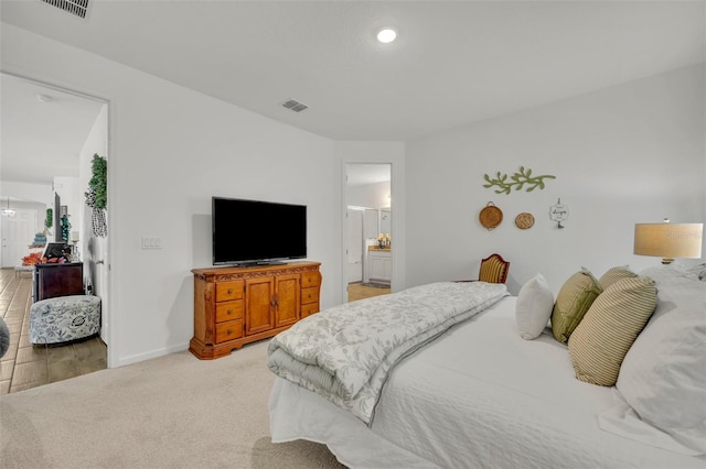 carpeted bedroom featuring ensuite bath