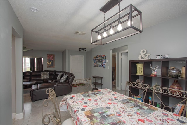 dining area featuring light tile patterned floors and a textured ceiling