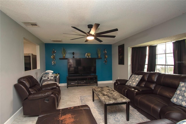 living room featuring a textured ceiling and ceiling fan