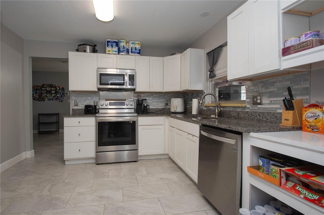 kitchen with stainless steel appliances, white cabinetry, and sink