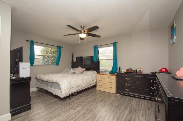 bedroom featuring hardwood / wood-style flooring, ceiling fan, and a textured ceiling