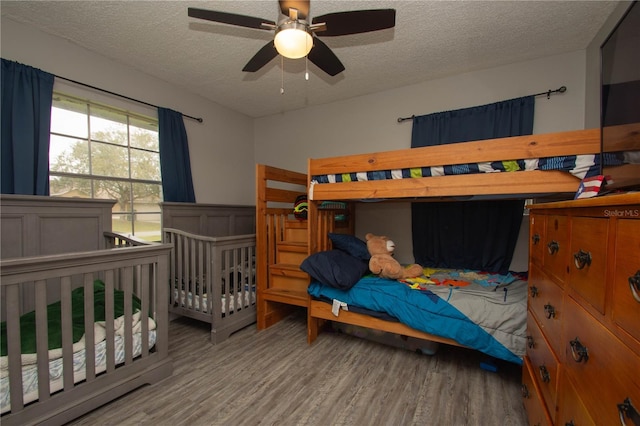 bedroom with wood-type flooring, ceiling fan, and a textured ceiling