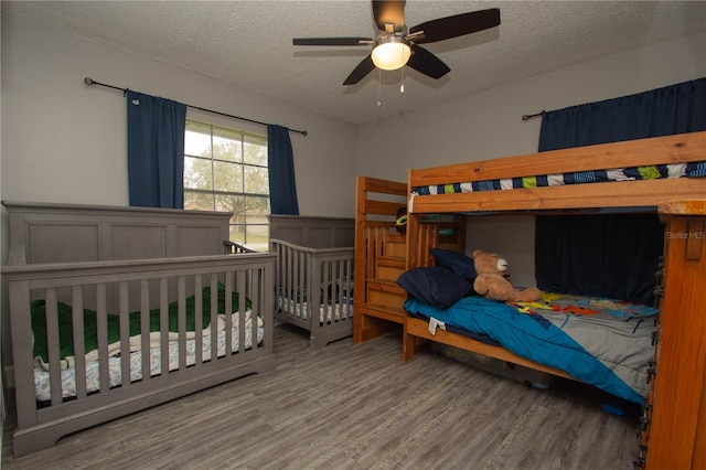 bedroom featuring ceiling fan, hardwood / wood-style floors, and a textured ceiling