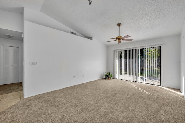 carpeted spare room with lofted ceiling, ceiling fan, and a textured ceiling