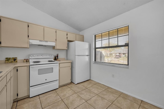 kitchen featuring lofted ceiling, light tile patterned floors, white appliances, cream cabinets, and a textured ceiling