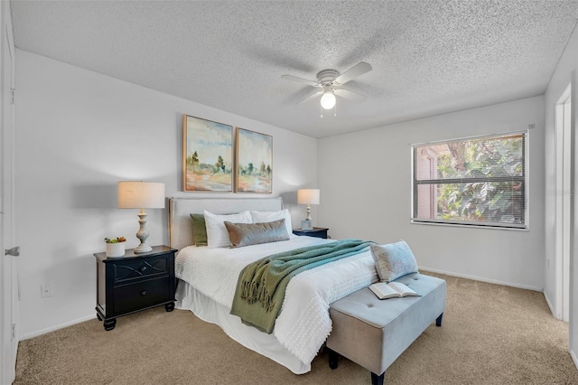 bedroom featuring ceiling fan, light colored carpet, and a textured ceiling