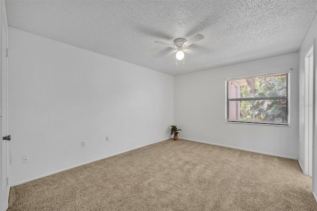 unfurnished room featuring ceiling fan, light colored carpet, and a textured ceiling