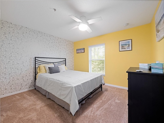 carpeted bedroom with a ceiling fan, wallpapered walls, and baseboards