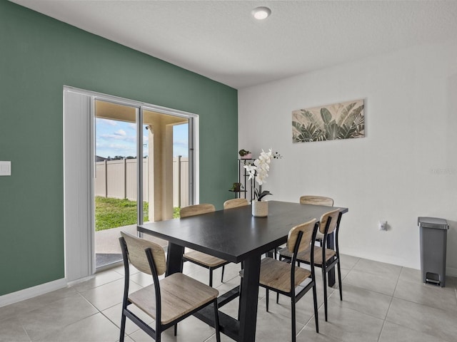 dining room featuring light tile patterned flooring and a textured ceiling