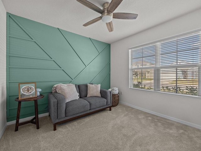 sitting room featuring ceiling fan, carpet floors, and a textured ceiling