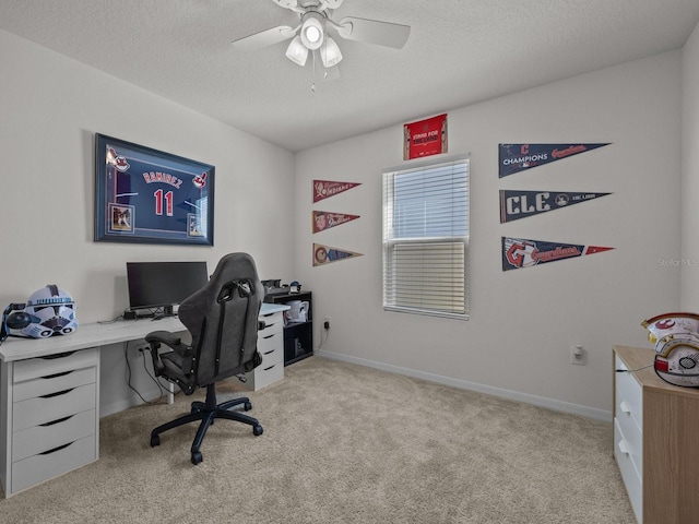 office space featuring light carpet, ceiling fan, and a textured ceiling