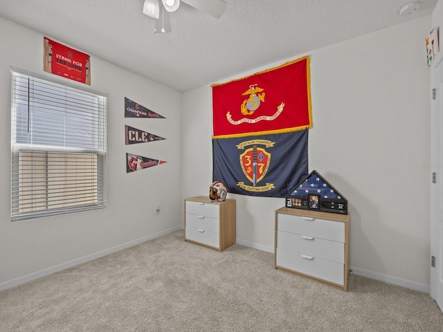 game room with ceiling fan, light carpet, and a textured ceiling