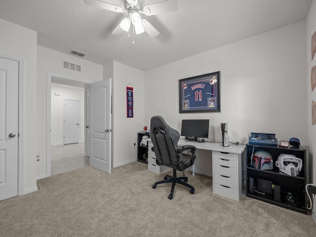 carpeted office space with ceiling fan and a textured ceiling