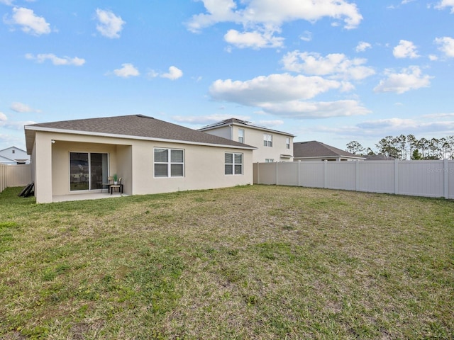 rear view of property with a patio and a yard