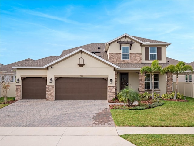 view of front of home featuring a front yard, stucco siding, decorative driveway, stone siding, and an attached garage