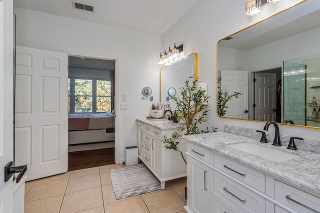 bathroom with tile patterned flooring, vanity, and walk in shower