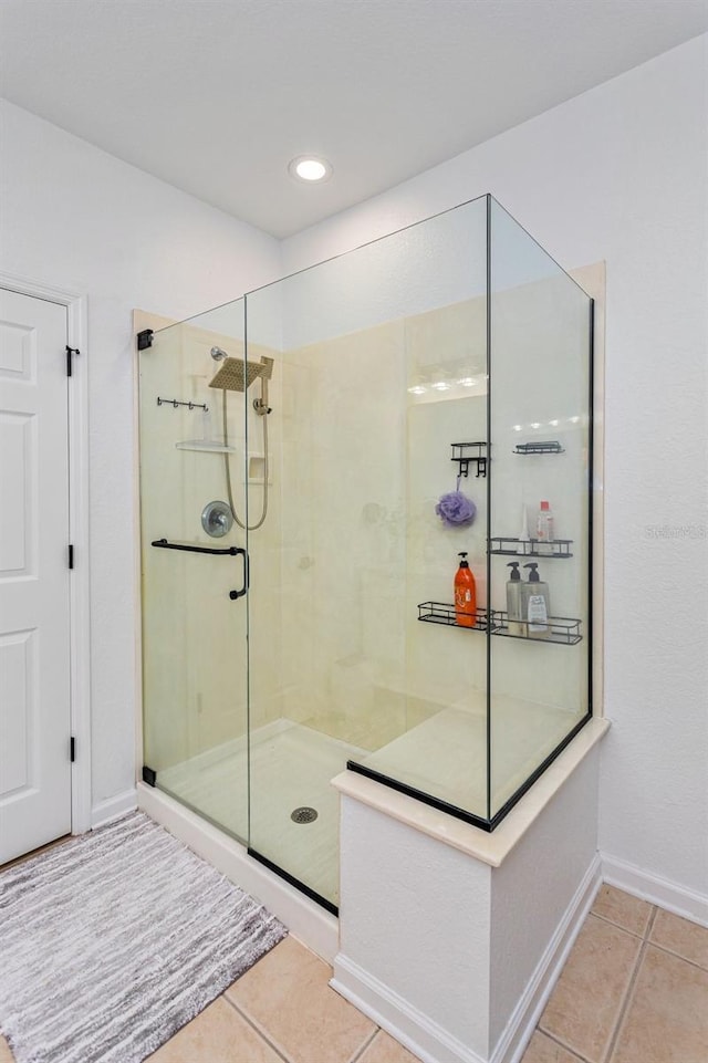 bathroom with a shower with door and tile patterned floors