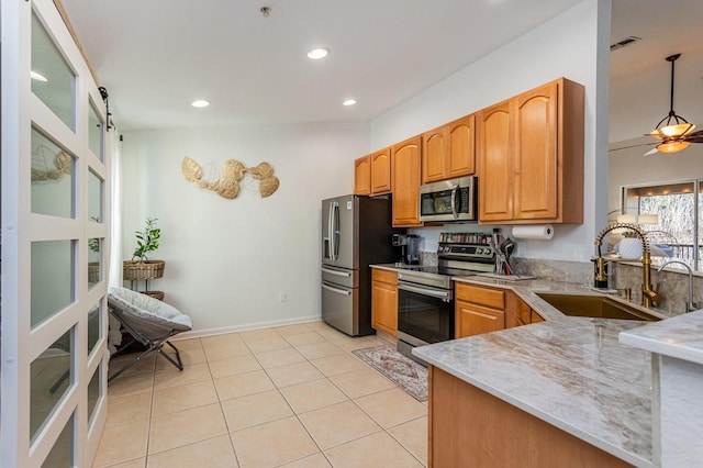 kitchen with sink, light tile patterned floors, appliances with stainless steel finishes, pendant lighting, and ceiling fan