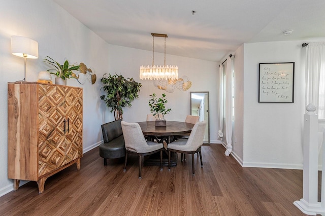 dining area with vaulted ceiling, dark hardwood / wood-style floors, and a notable chandelier