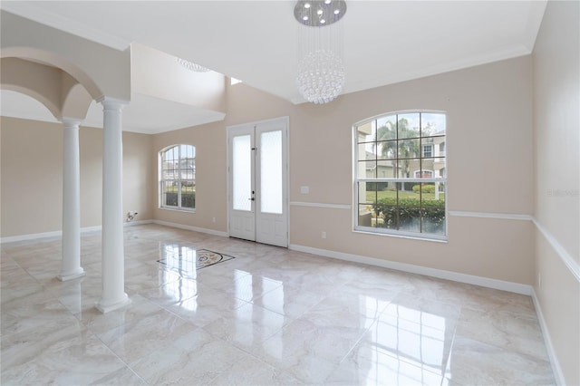 empty room featuring ornamental molding, a chandelier, and ornate columns