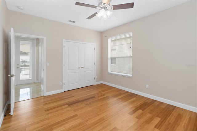 unfurnished bedroom with hardwood / wood-style floors, a closet, and ceiling fan