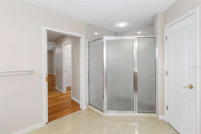 bathroom featuring a shower with door and tile patterned flooring