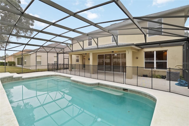 view of swimming pool featuring a lanai, central AC unit, ceiling fan, and a patio area