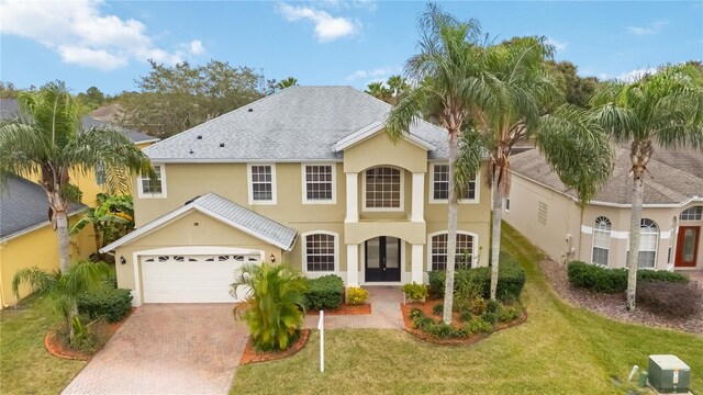 view of front of home featuring french doors, a garage, and a front lawn