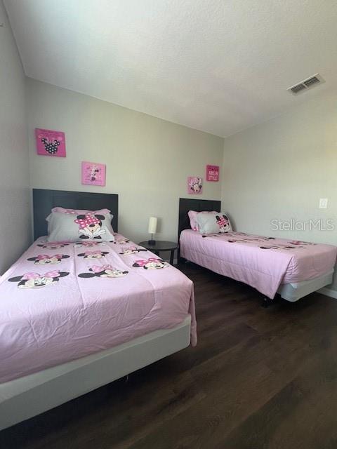 bedroom with lofted ceiling and dark wood-type flooring