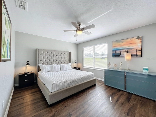 bedroom featuring ceiling fan, dark hardwood / wood-style flooring, and a textured ceiling