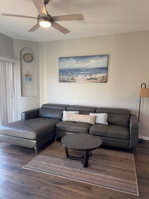 living room with wood finished floors and ceiling fan