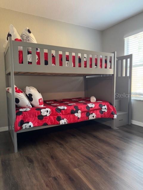 bedroom featuring baseboards and wood finished floors