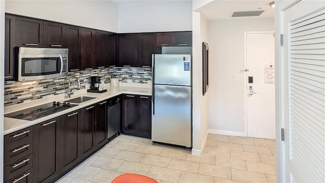 kitchen featuring visible vents, black appliances, light countertops, and a sink