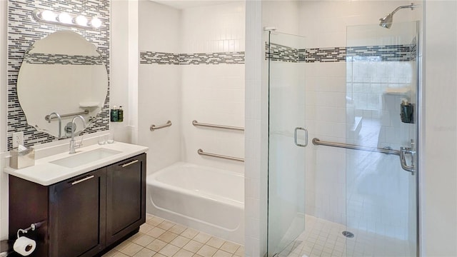 full bathroom featuring tile patterned floors, backsplash, a tile shower, a bathtub, and vanity