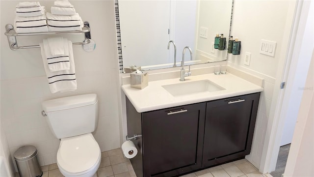 bathroom with vanity, wainscoting, tile walls, toilet, and tile patterned floors