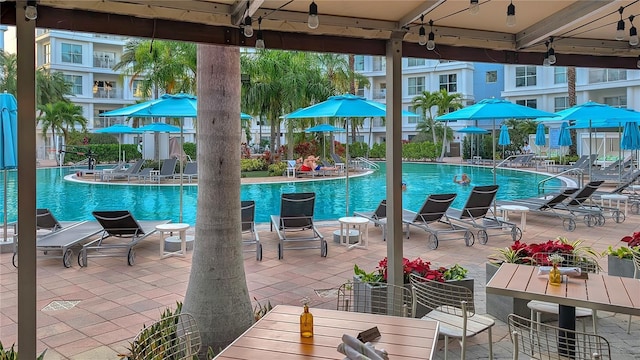 pool with outdoor dining area and a patio