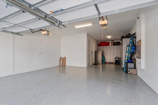 garage with a garage door opener and stainless steel refrigerator