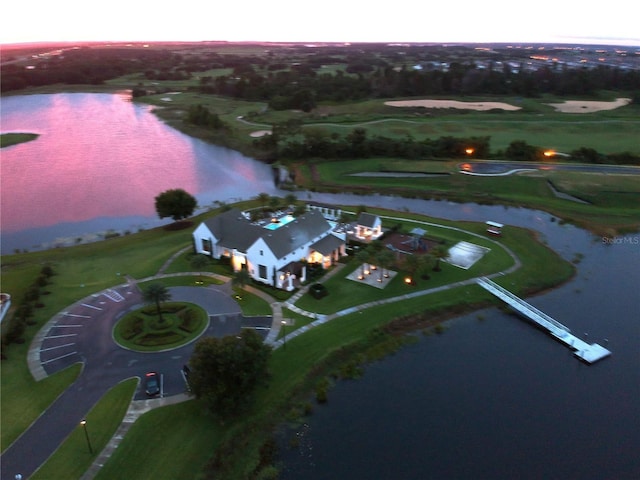 aerial view at dusk featuring a water view