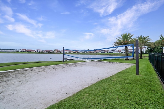 view of community featuring a water view, a yard, and volleyball court