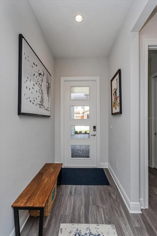 doorway with dark wood-type flooring and a textured ceiling