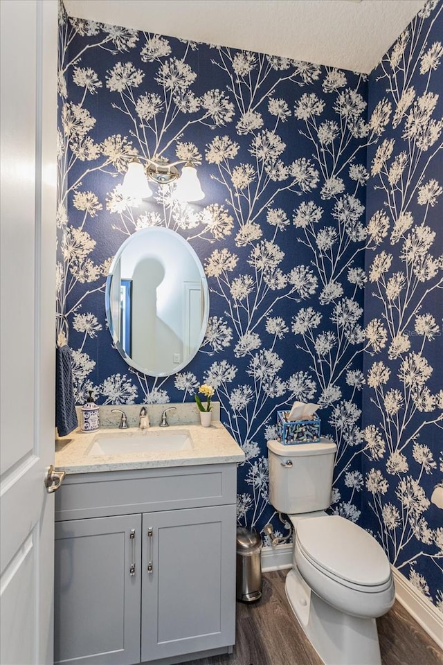 bathroom featuring vanity, hardwood / wood-style floors, and toilet