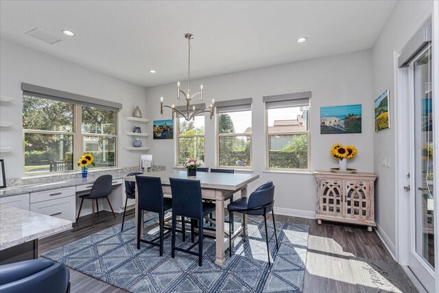 dining space with plenty of natural light, dark hardwood / wood-style floors, and a chandelier