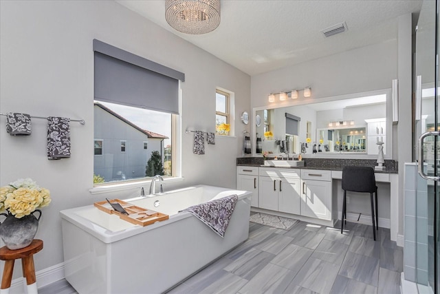 bathroom featuring vanity and independent shower and bath