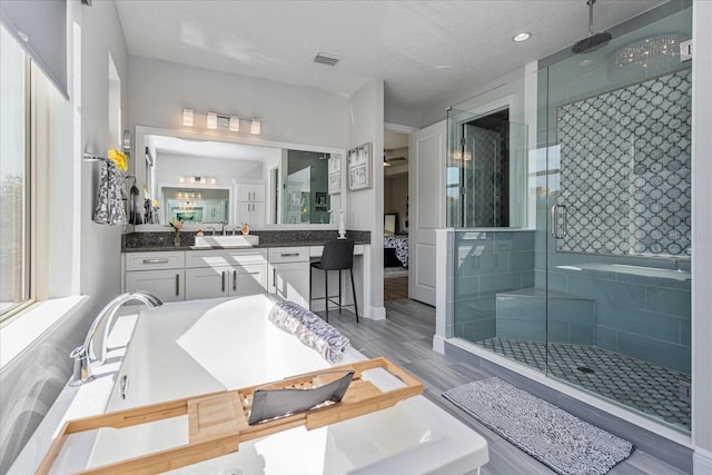 bathroom featuring vanity and a shower with door