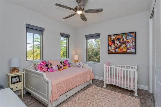 bedroom featuring hardwood / wood-style floors, a textured ceiling, and ceiling fan