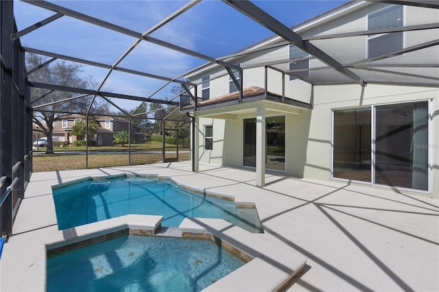 view of pool with an in ground hot tub, a patio, and glass enclosure